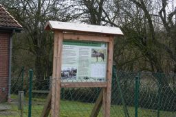 Informationstafel hinterm Zaun